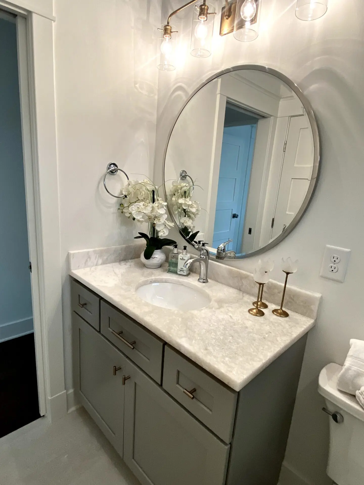 circular mirror on top of a bathroom sink